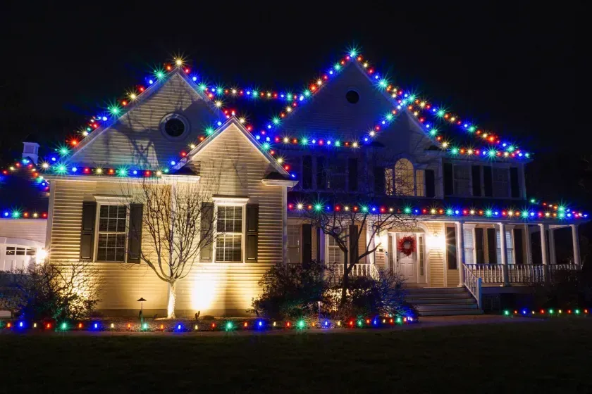 House decorated with colorful Christmas lights at night.