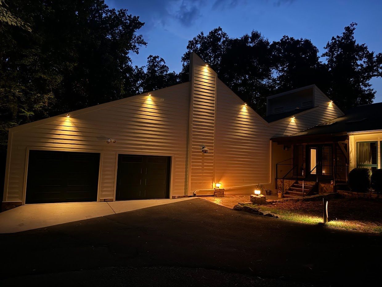 House exterior illuminated at night, featuring a two-car garage and trees.