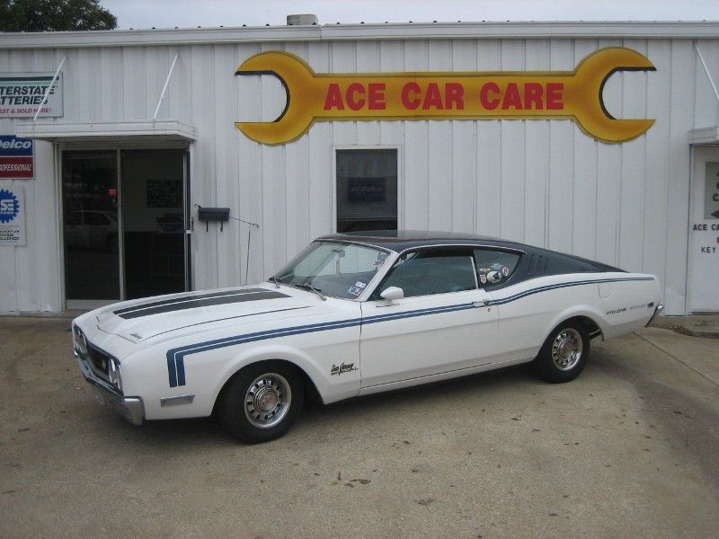 A white car is parked in front of ace car care