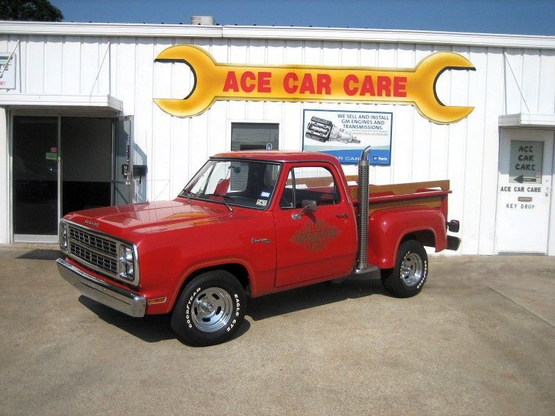 A red truck is parked in front of ace car care