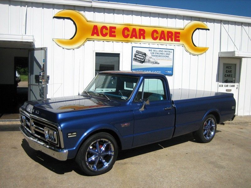 A blue truck is parked in front of ace car care