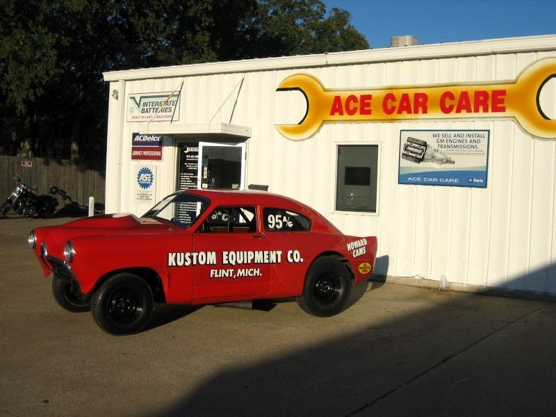 A red car is parked in front of ace car care