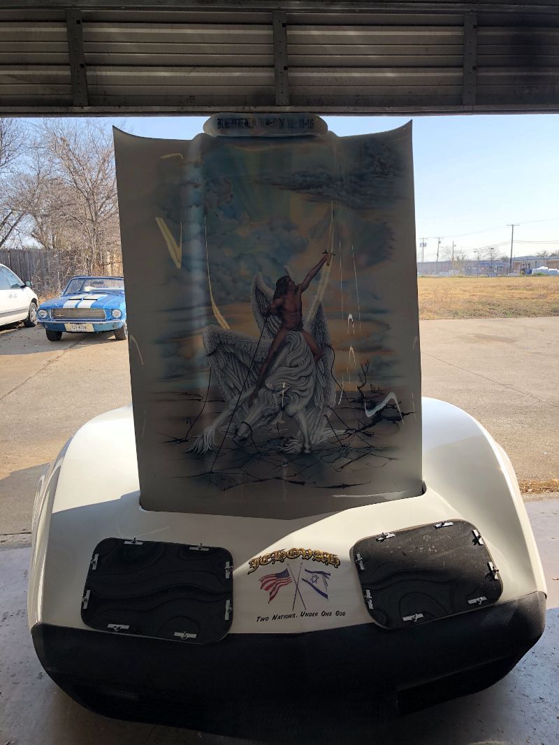 A painting of a man on a horse is on the back of a golf cart.