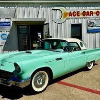 A green and white car is parked in front of a building.