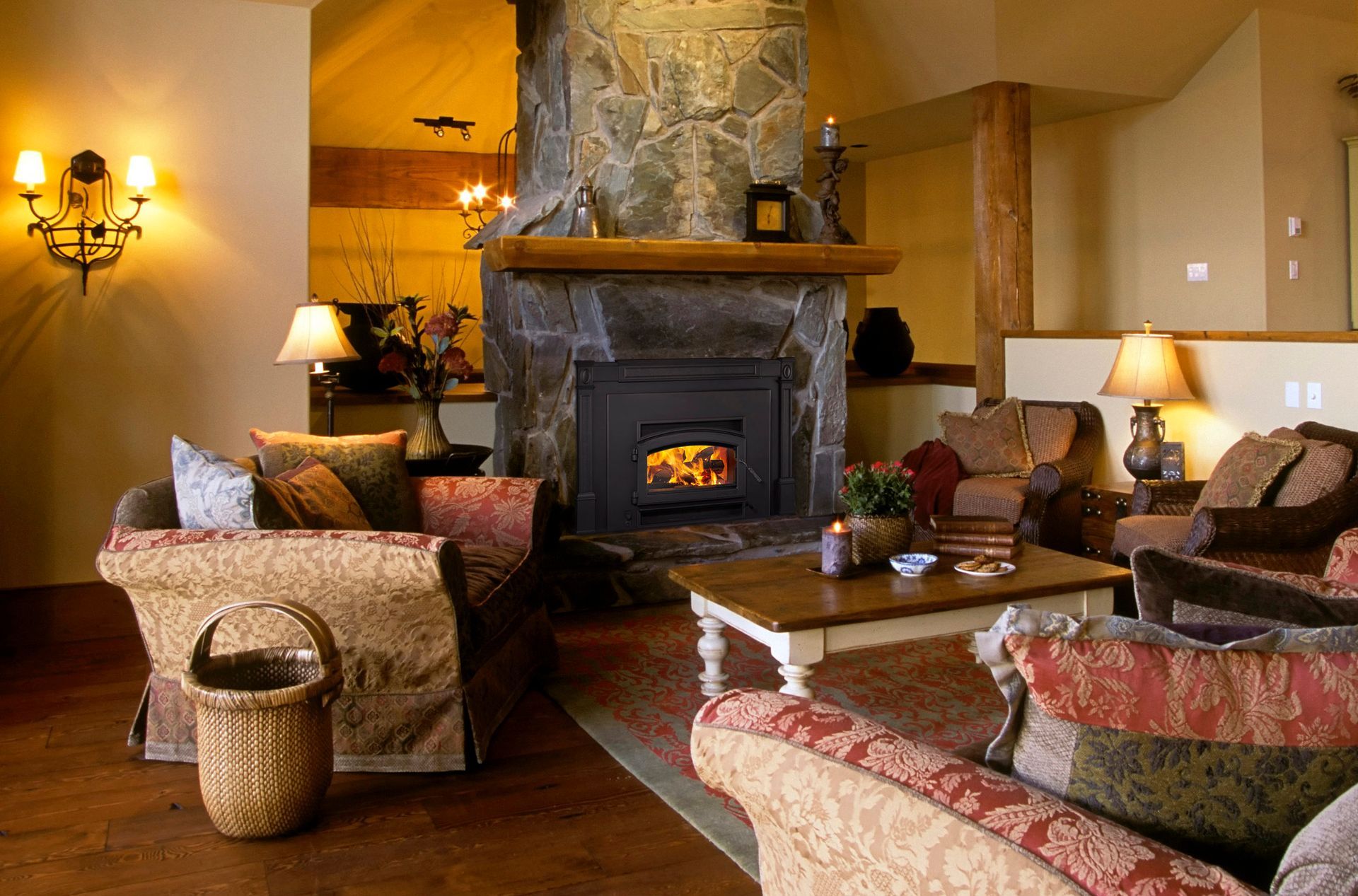 Cozy living room with stone fireplace, couches, coffee table, and warm lighting