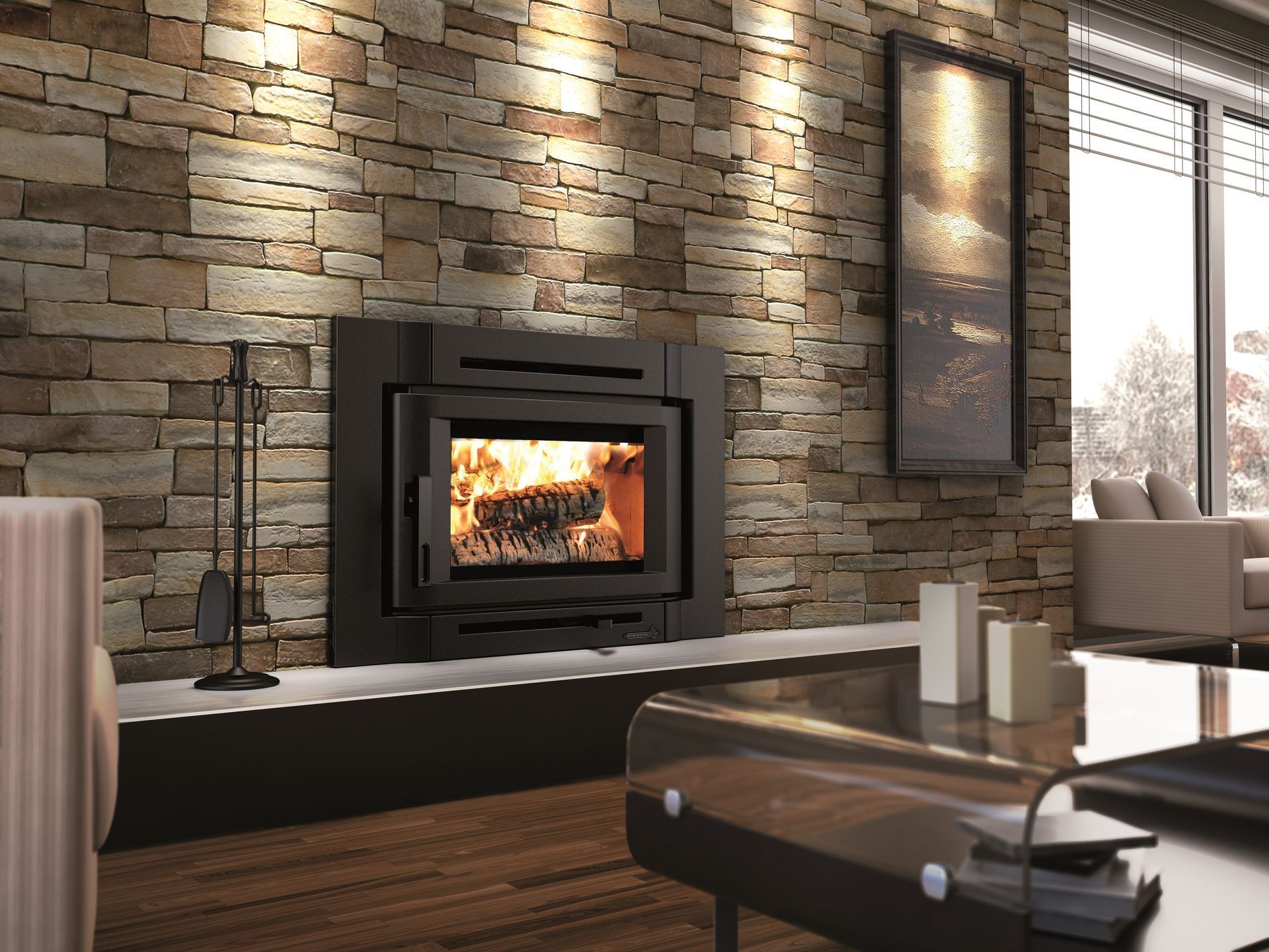 Fireplace with burning logs set into a stone wall, in a living room