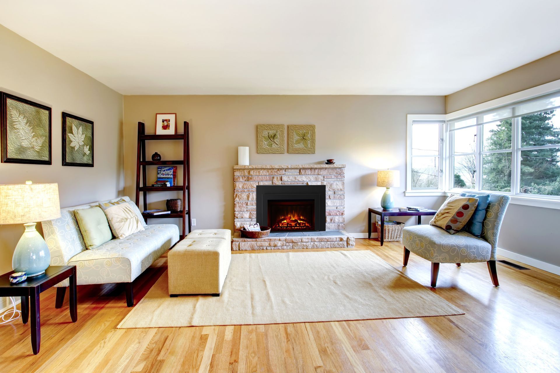 Living room with fireplace, couch, chair, wooden floor, and a window with a view.