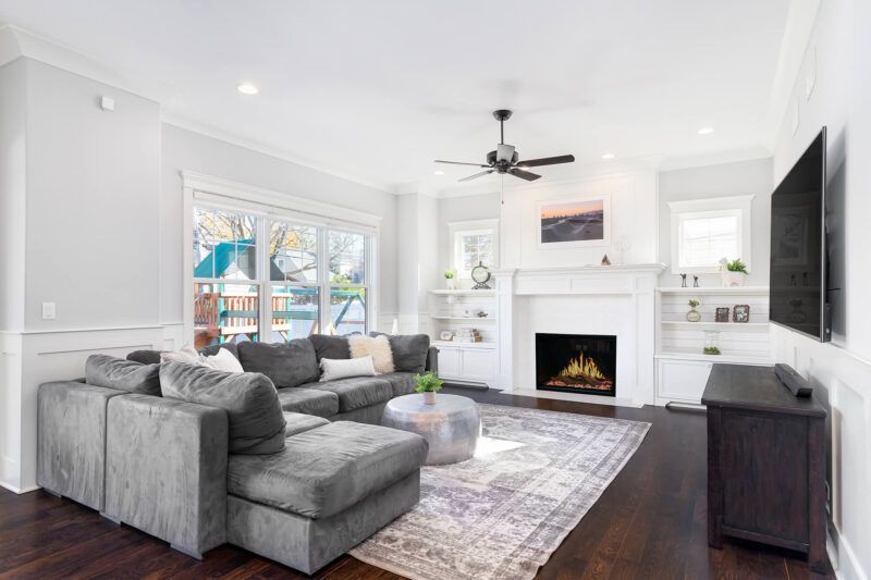 Gray sectional sofa in a bright living room with fireplace and TV.