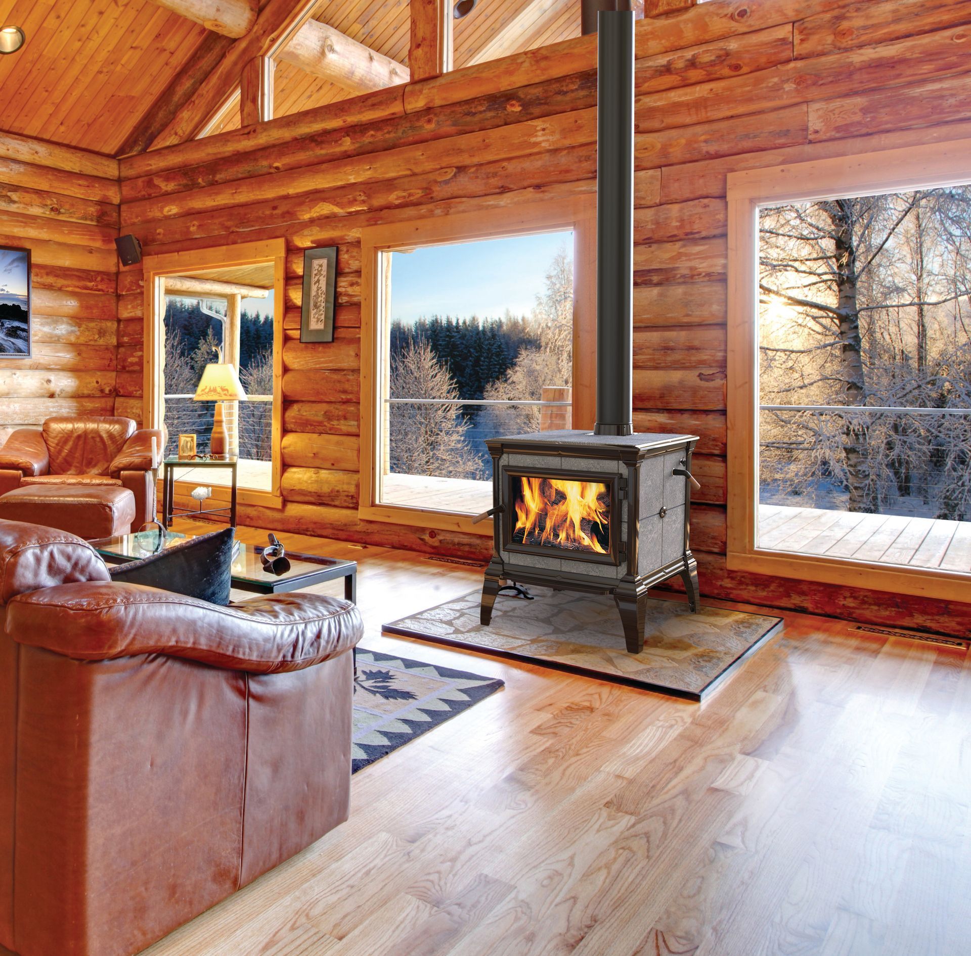 Cozy log cabin living room with a lit wood stove, leather furniture, and winter landscape views through large windows.