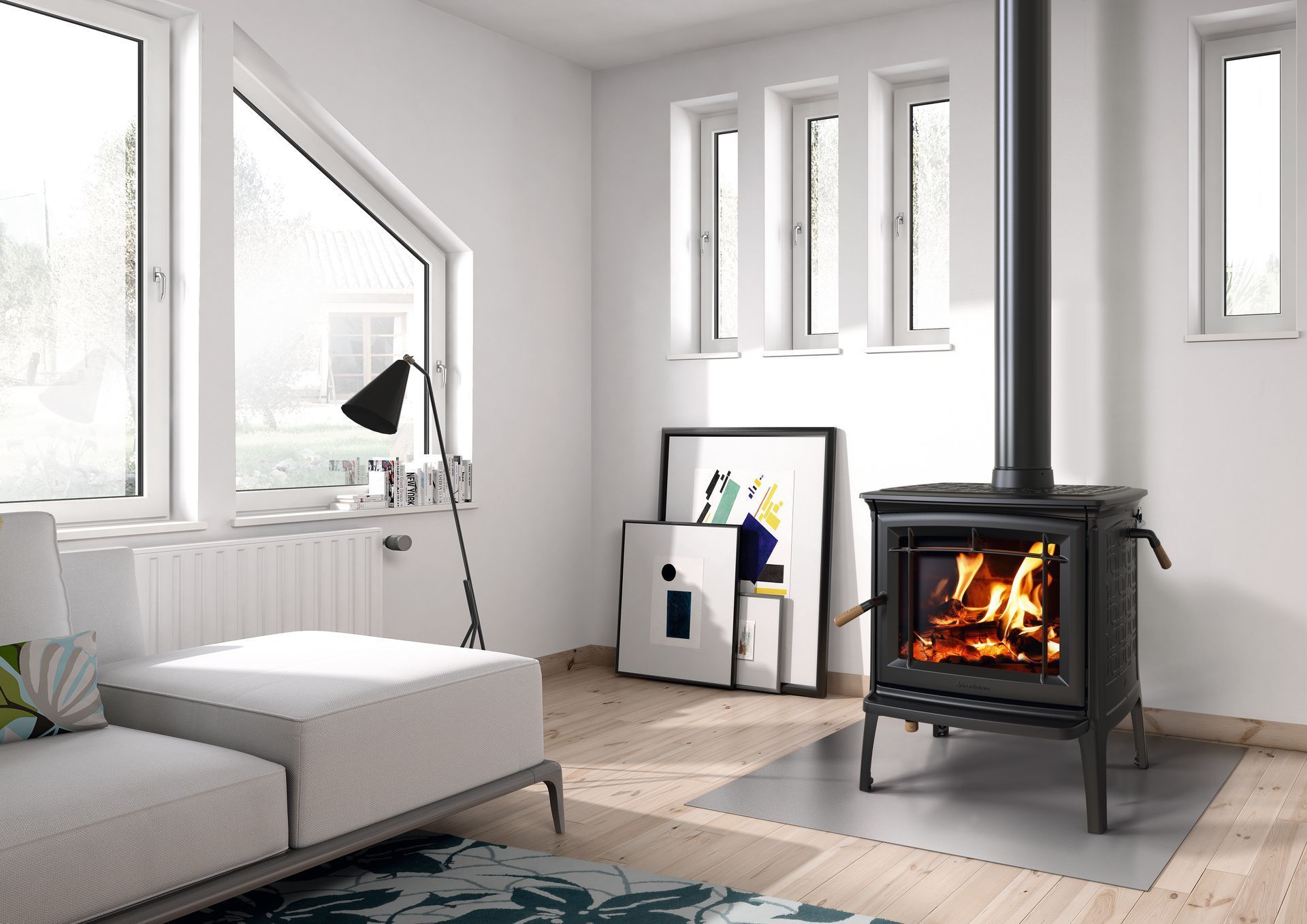 Cozy living room with burning black wood stove. White walls, windows, and light gray sofa.