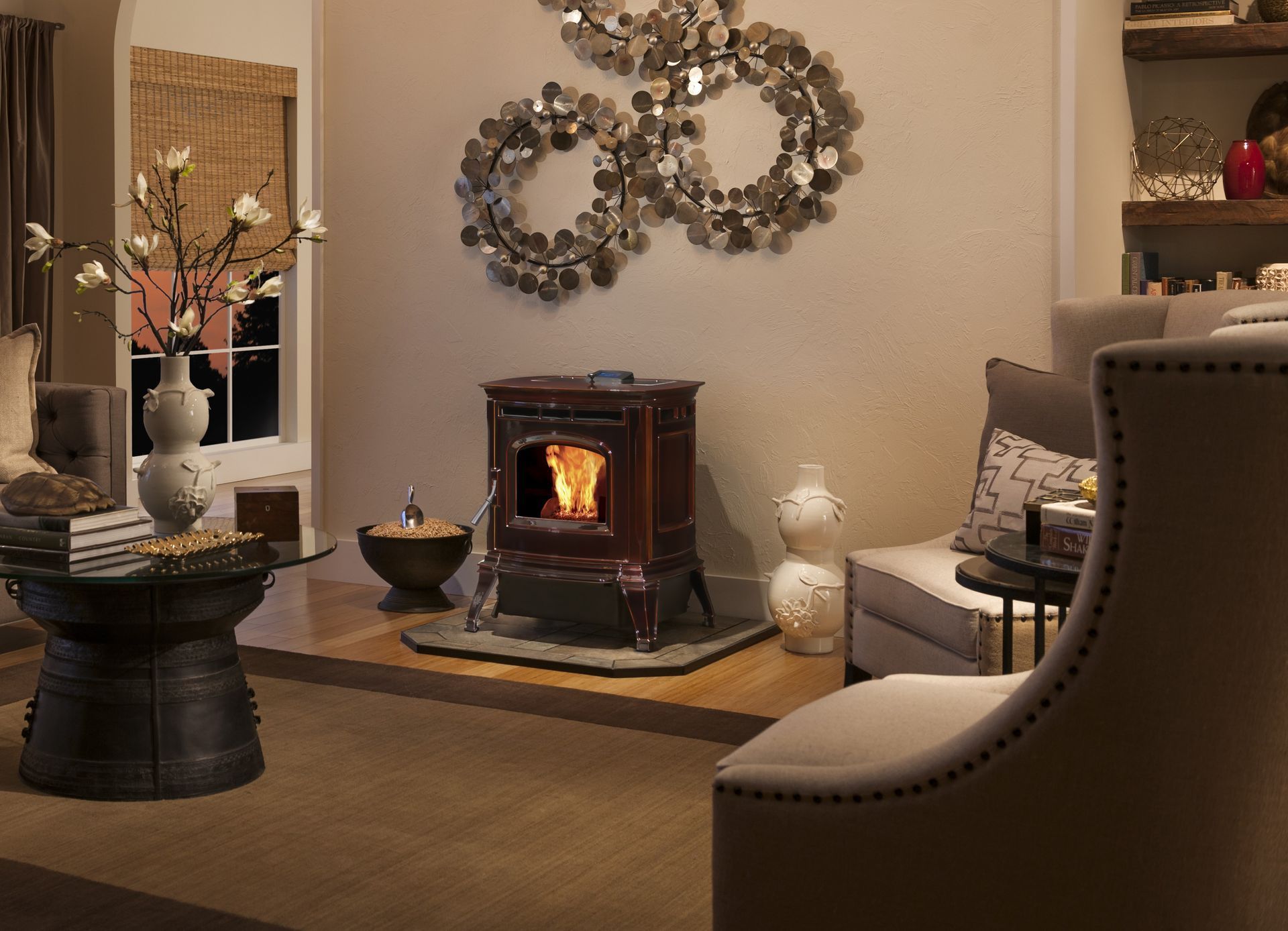 Cozy living room with a lit wood stove. Soft lighting, neutral tones, and modern decor create a warm atmosphere.