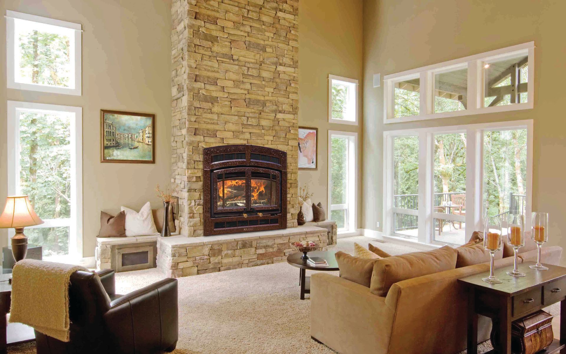 Living room with stone fireplace, beige walls, large windows, and neutral-toned furniture.