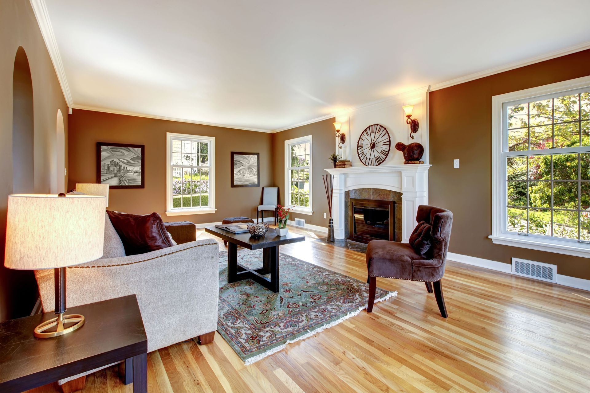 Living room with brown walls, white trim, fireplace, and hardwood floors.