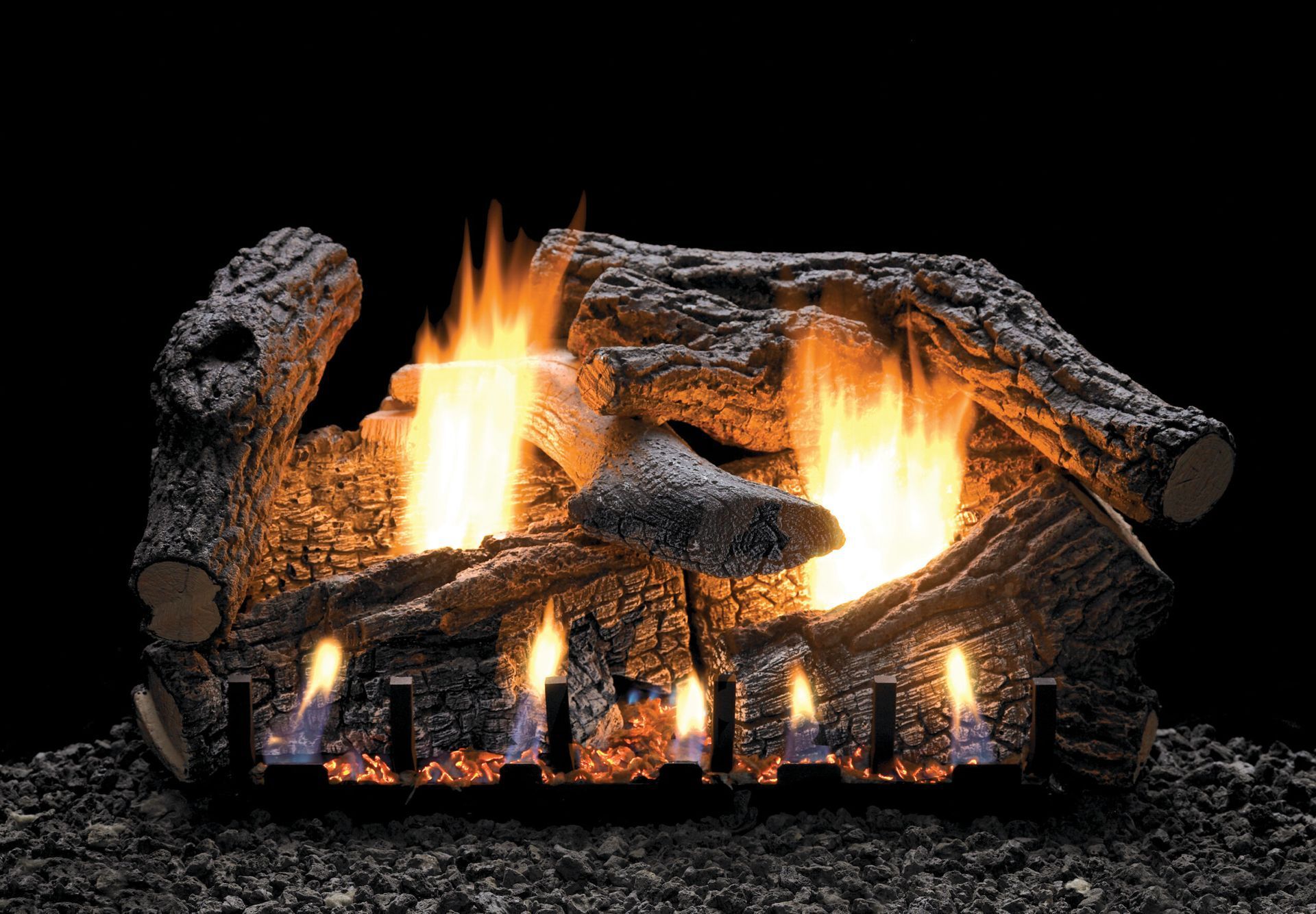 Gas fireplace with glowing flames and faux logs, set against a dark background.