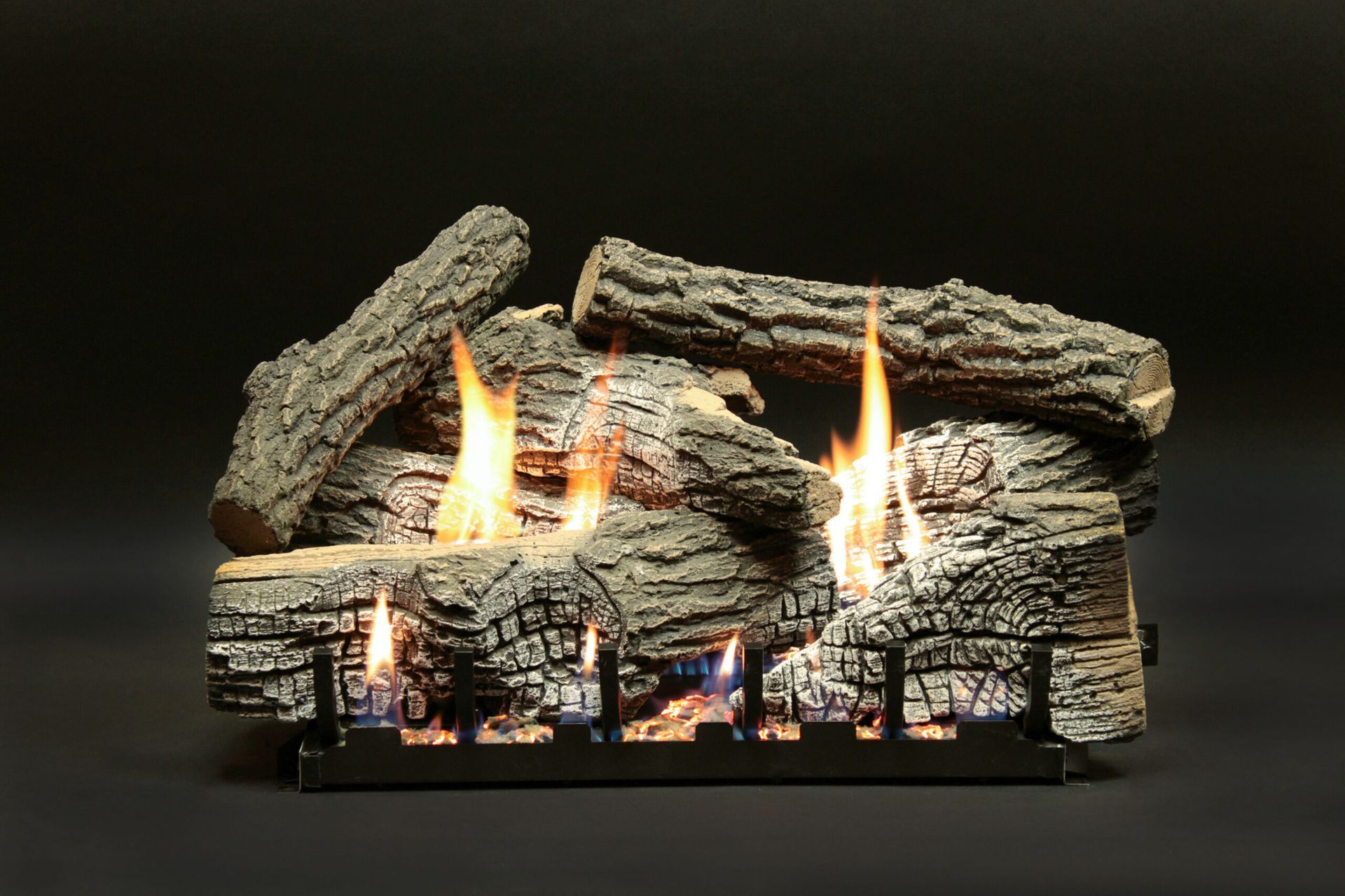 Gas fireplace logs with flames burning against a black background.