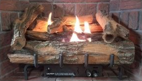 Gas fireplace with ceramic logs and flames, set in a brick hearth.