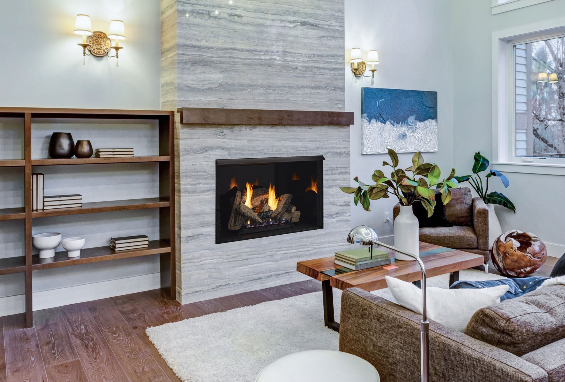 Living room with fireplace, bookshelves, and modern furniture. Light blue walls, gray fireplace, wooden floors.