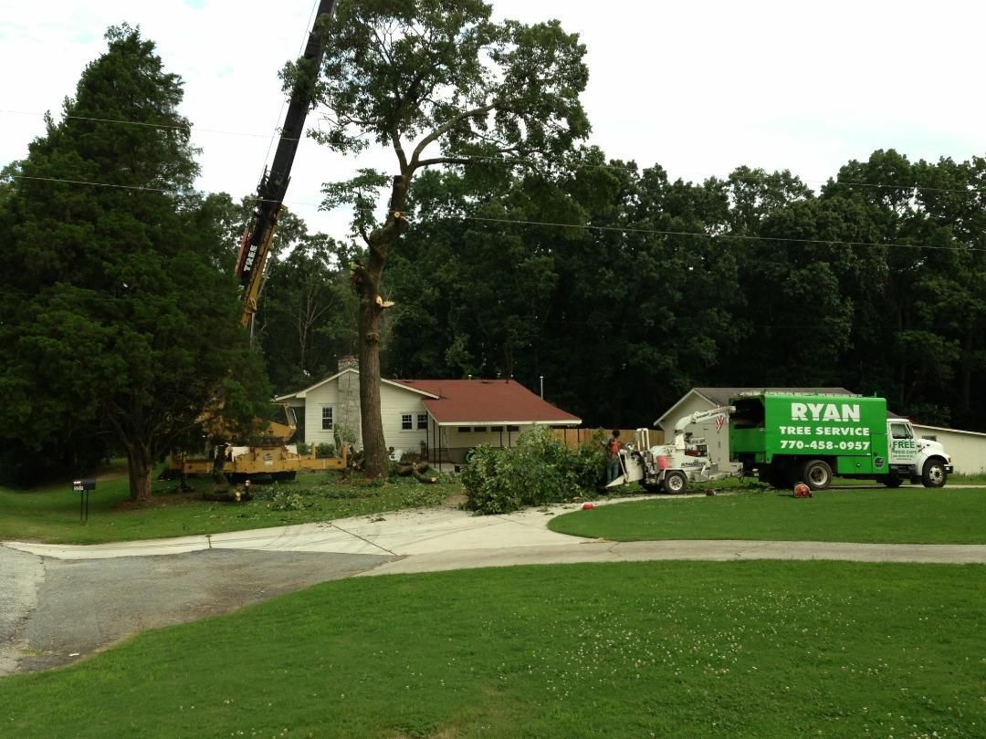 A green ryan truck is parked in front of a house