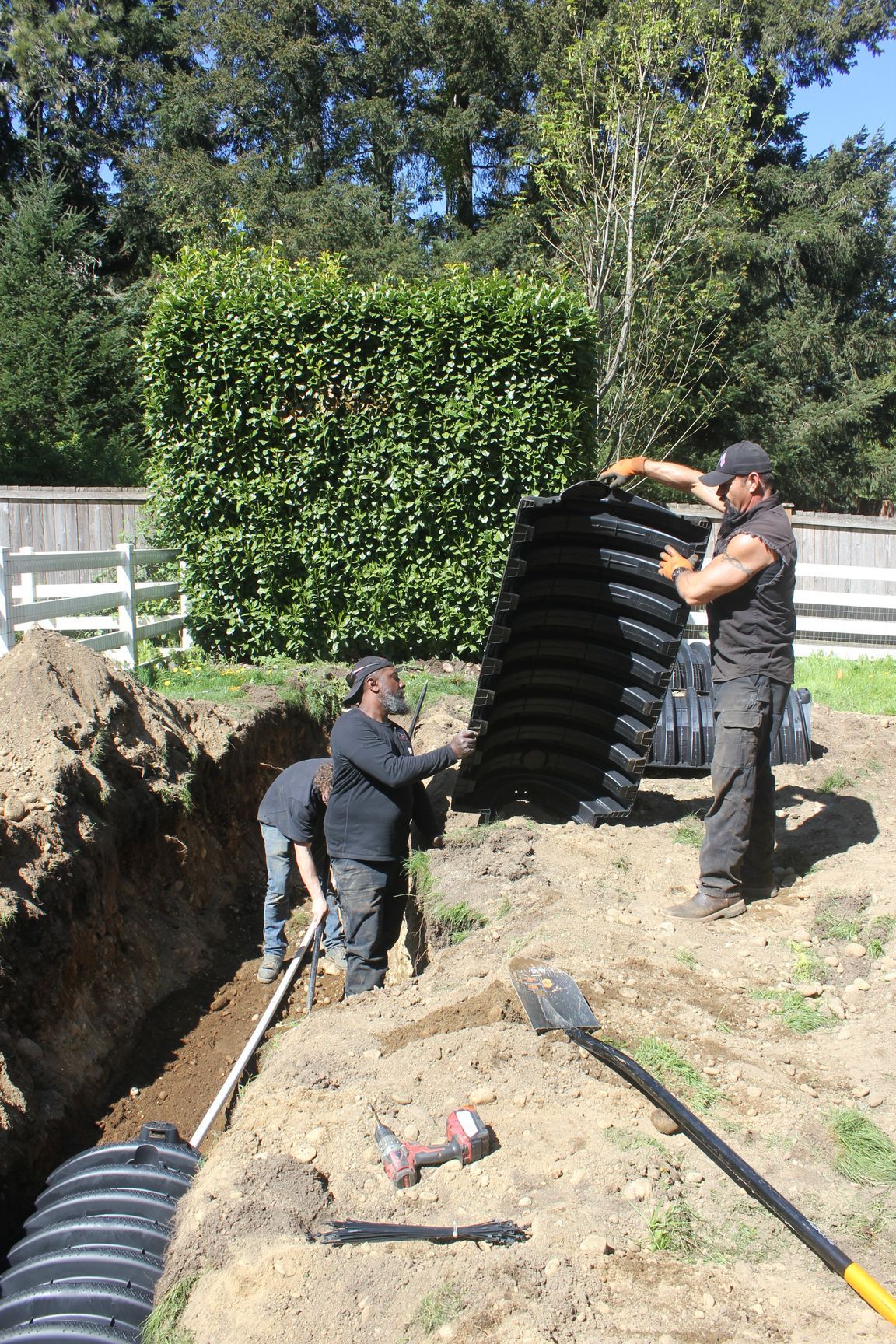 A group of men are working on a septic system.