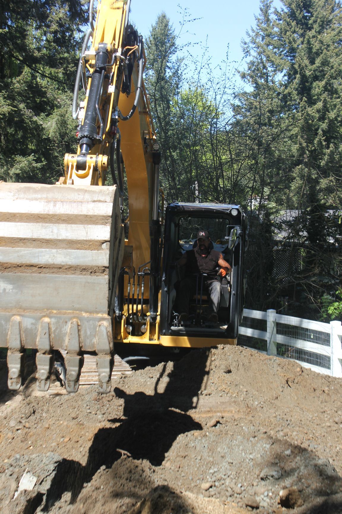 A yellow excavator is digging a hole in the ground