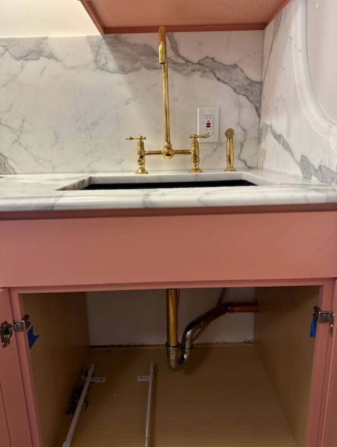 A pink cabinet with a sink underneath it