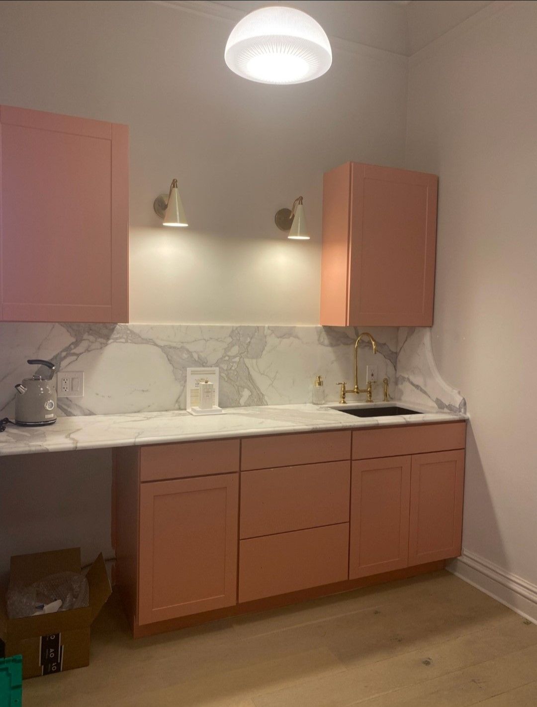 A kitchen with pink cabinets and a sink