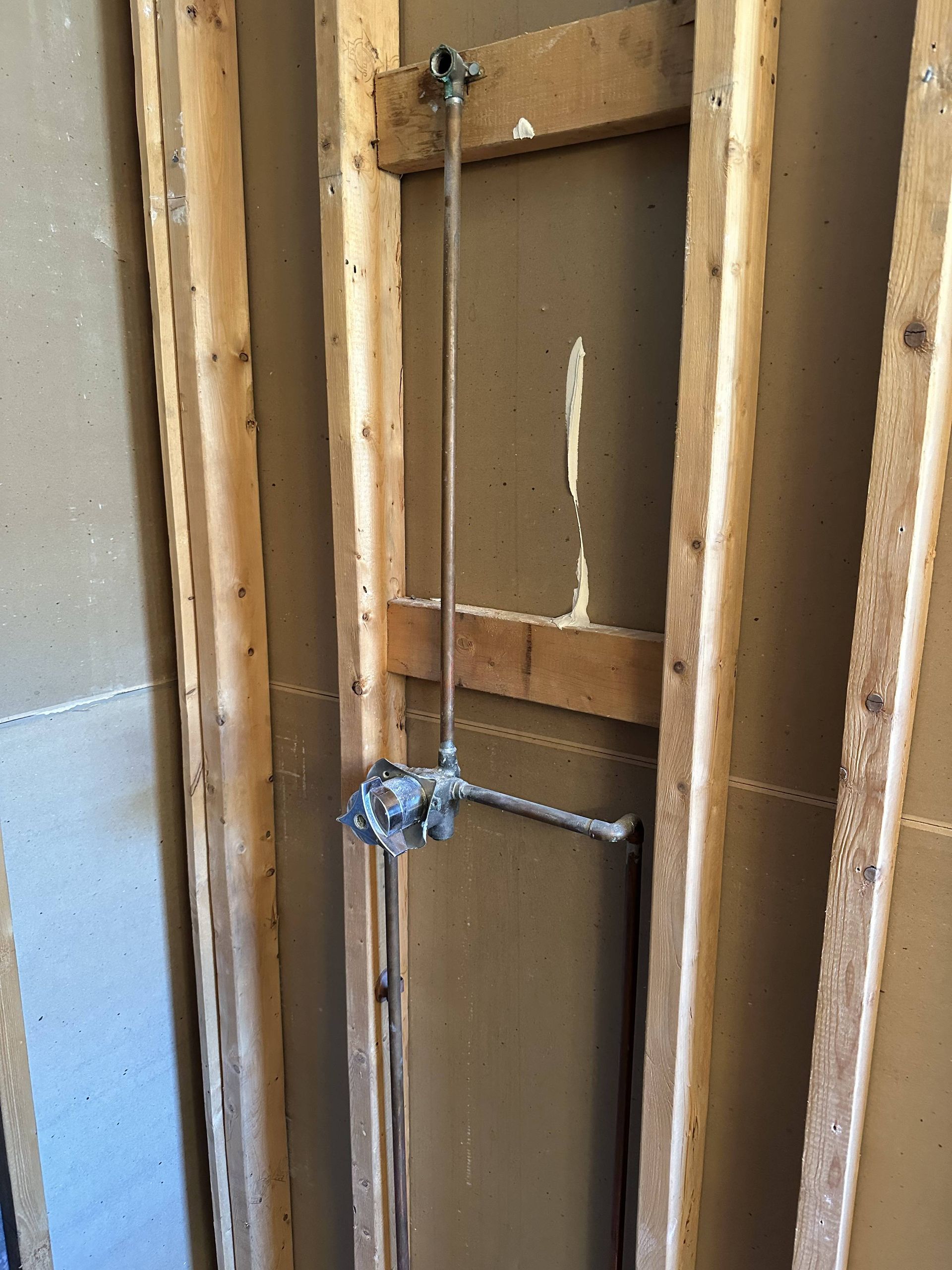 A shower head is attached to a wooden wall.