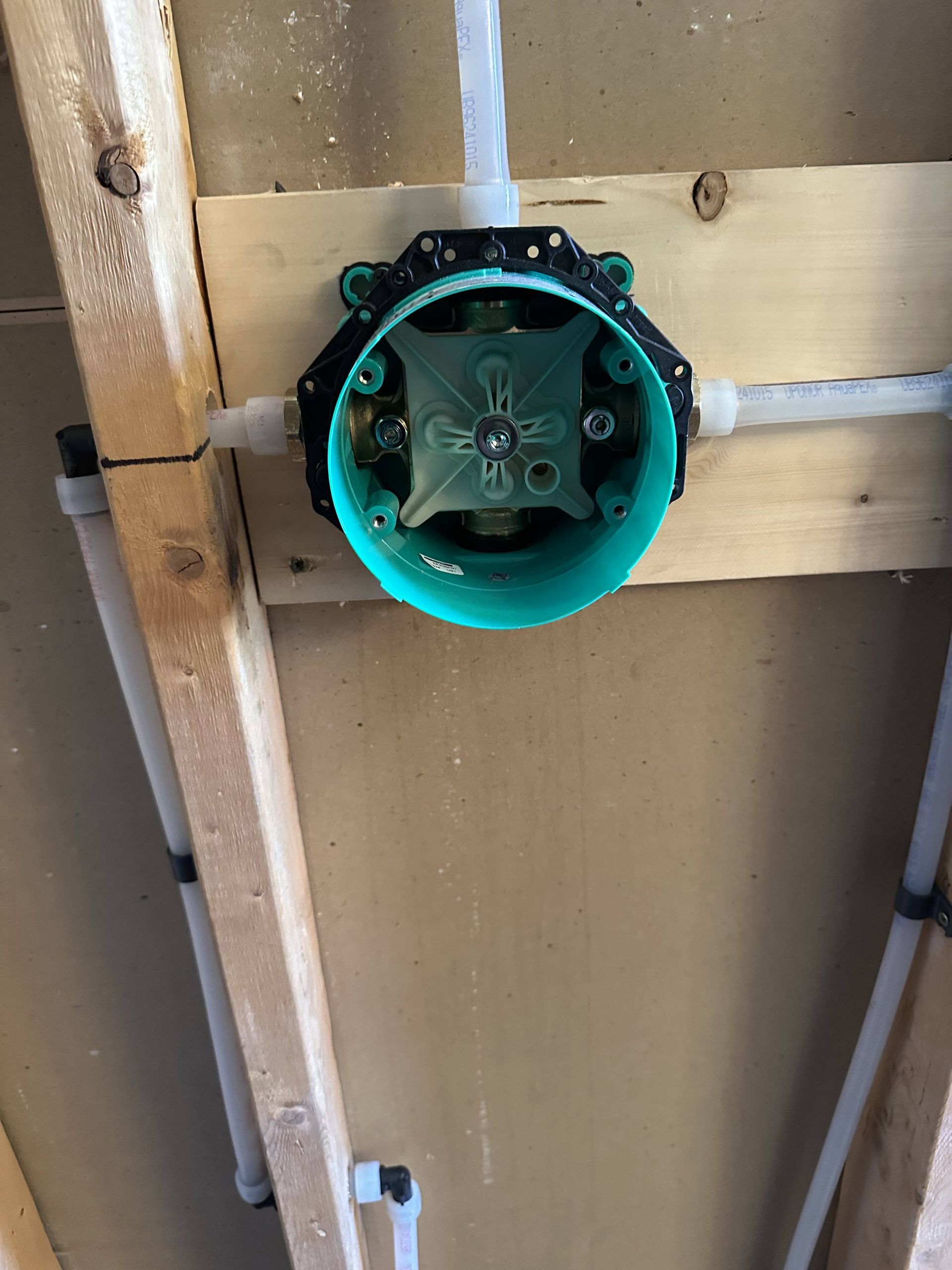 A pipe is being installed in a wooden wall.