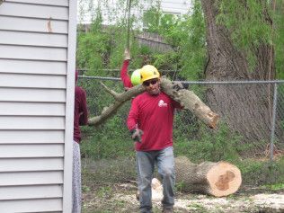A man is carrying a large log on his shoulders.