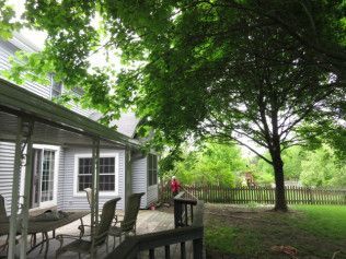 A deck with a table and chairs in front of a house