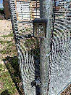 A close up of a gate with a keypad attached to it.