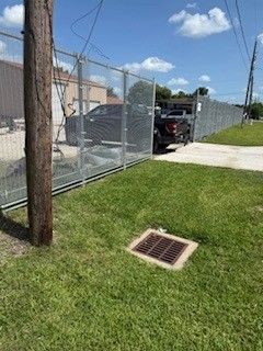 A truck is parked in the grass next to a fence.