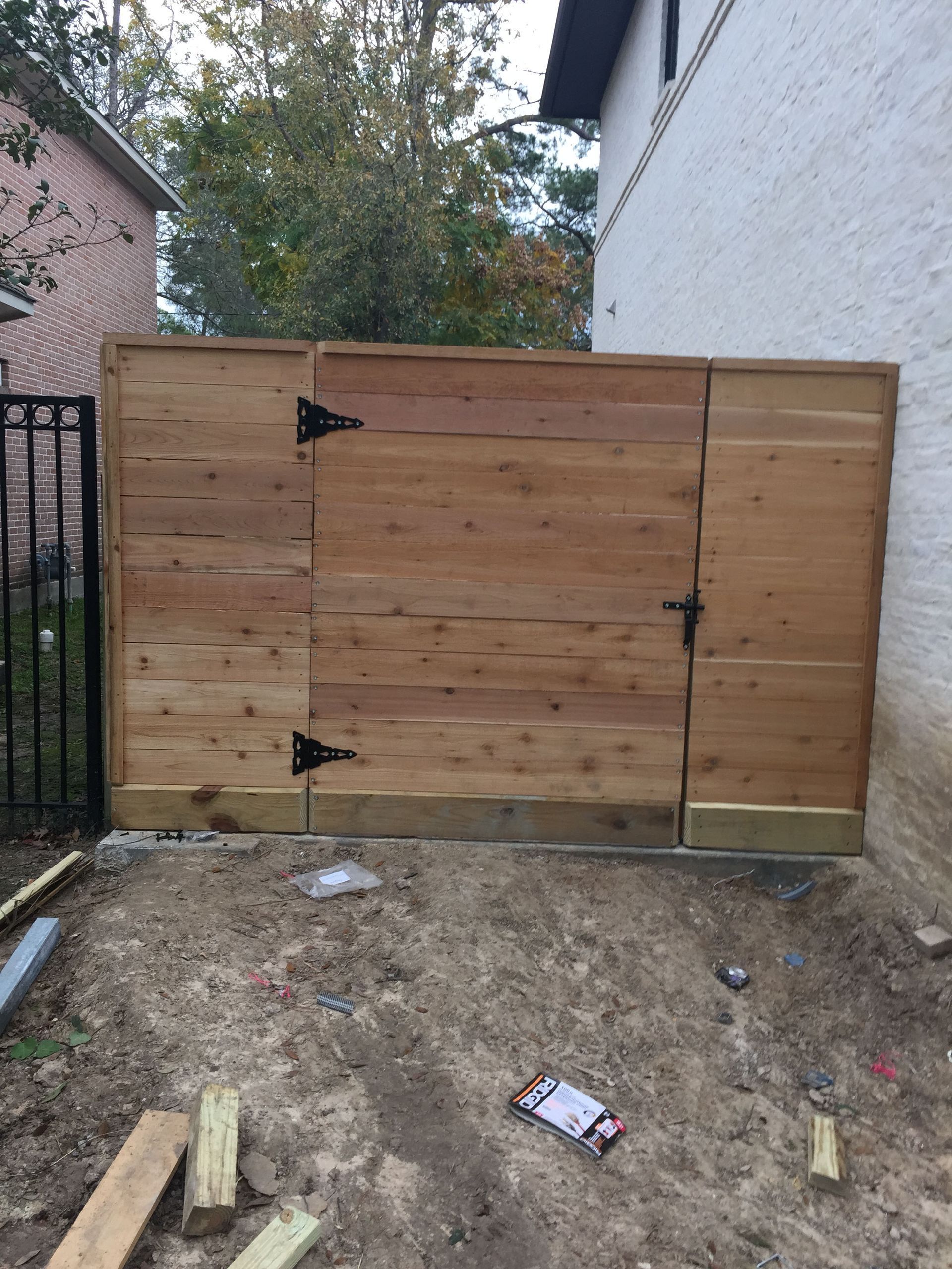 A wooden fence is being built in front of a house