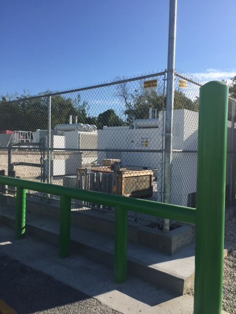 A green fence with a chain link fence behind it