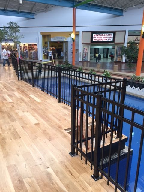 A fence surrounds a swimming pool in a mall