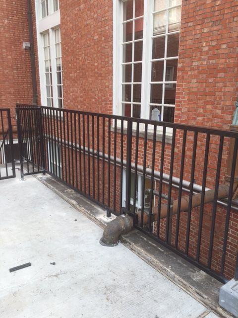 A brick building with a black railing in front of it