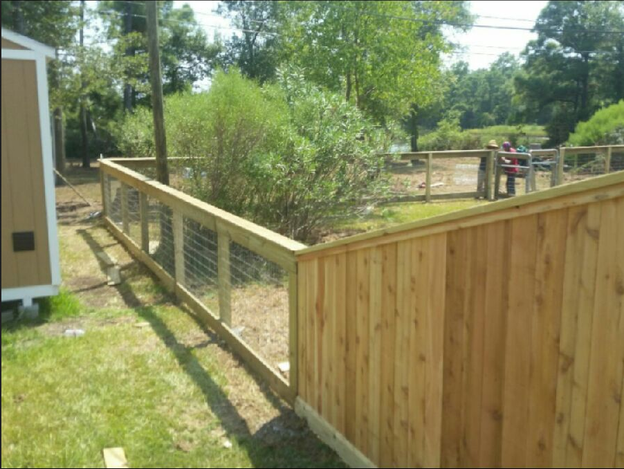 A wooden fence with a wire fence around it