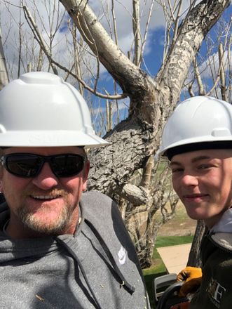a man and teenage with white hard hats on