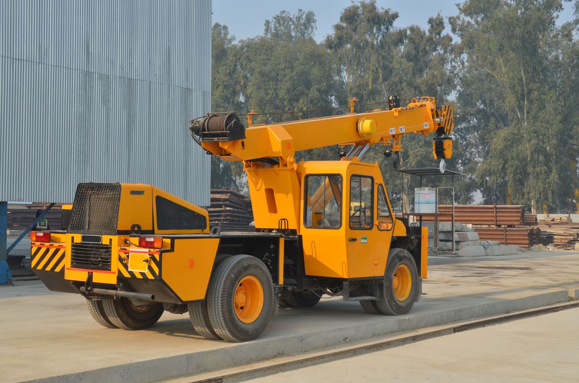 Compact mobile crane parked at industrial site