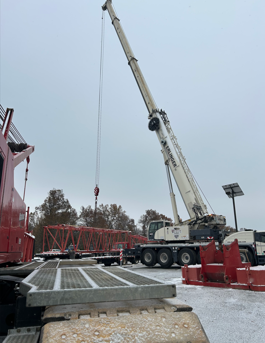 A large crane is lifting something in a parking lot