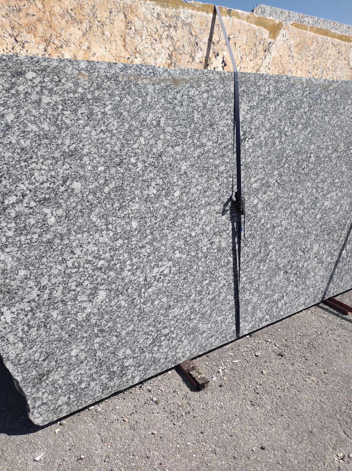 A large piece of granite is sitting on the ground.