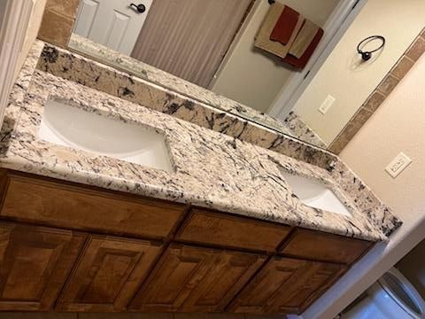 A bathroom with two sinks and a large mirror.