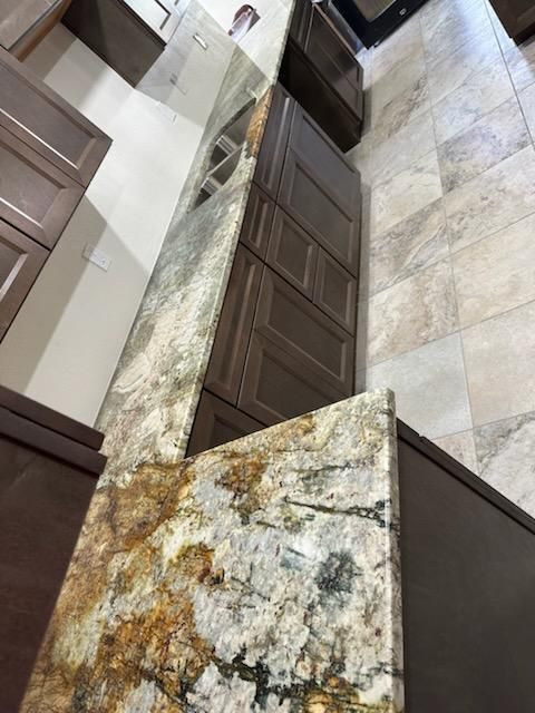 A kitchen with granite counter tops and brown cabinets