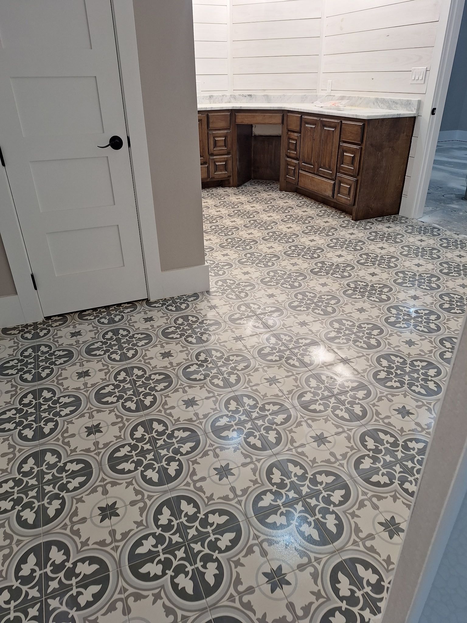 A bathroom with a tiled floor and a sink.