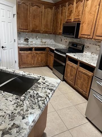 A kitchen with wooden cabinets , granite counter tops , stainless steel appliances and a sink.