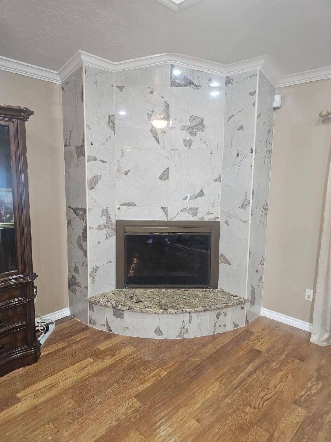 A living room with a fireplace and hardwood floors.
