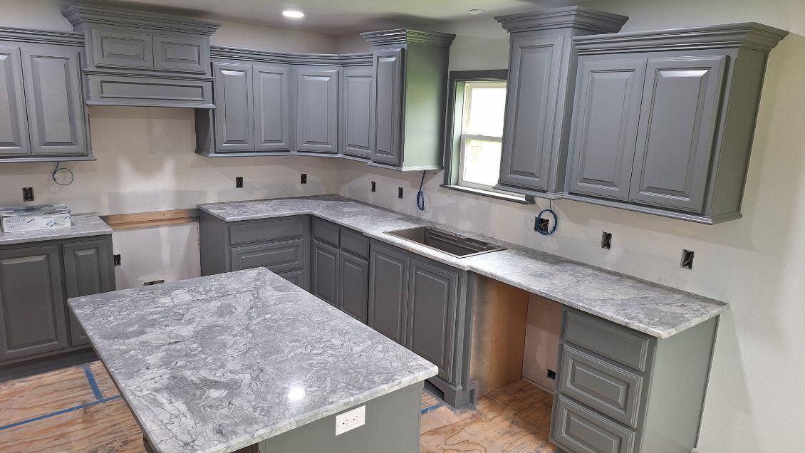 A kitchen with gray cabinets and granite counter tops is being remodeled.