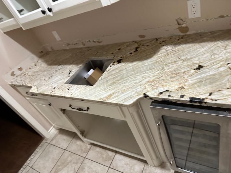 A kitchen counter with a sink and a refrigerator