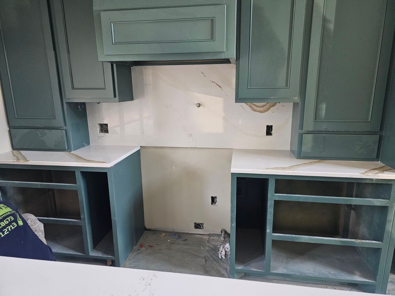 A kitchen with blue cabinets and white counter tops