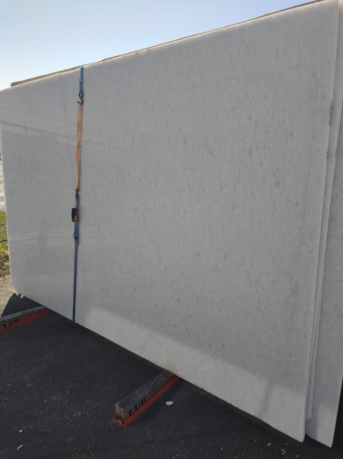A large white slab of marble is sitting on a rack